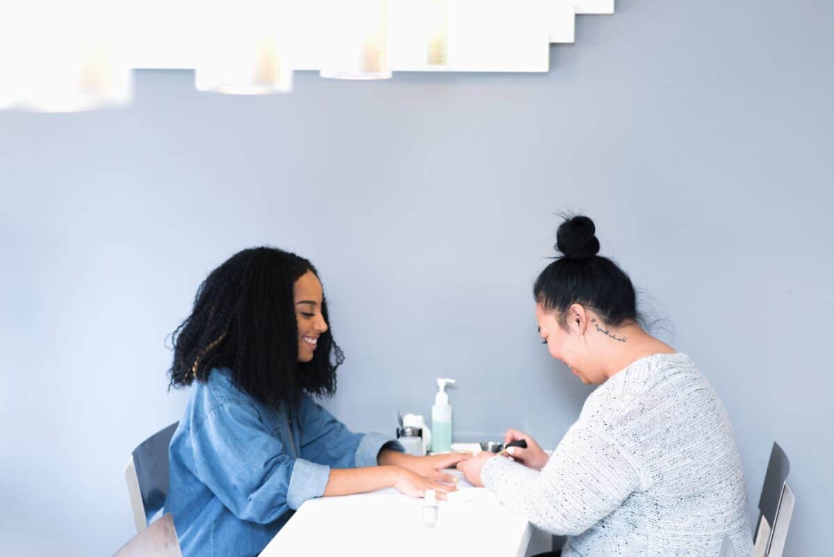 woman getting her nails painted by a TEN SPOT employee 