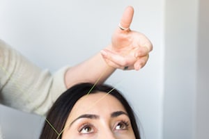 a woman getting her eyebrows threaded
